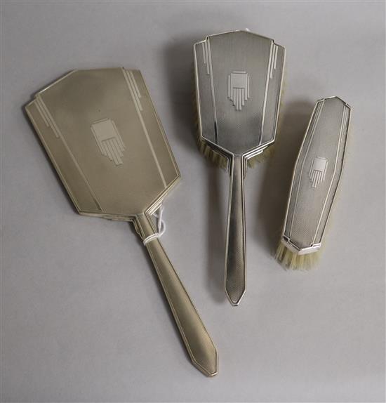 An Art Deco style silver mounted three piece mirror and brush set.